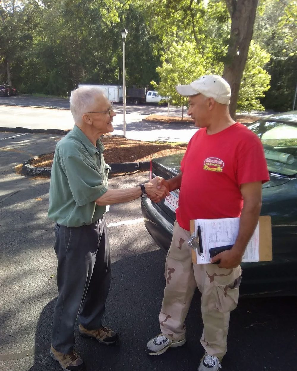 Paulista Moving specialist shaking hands with a customer holding estimate clipboard